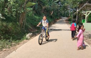 Bocah Warga Ciandam, Merasa Asyik Bersepeda Dijalan Yang Sudah di Betonasi Oleh Satgas TMMD Ke – 111