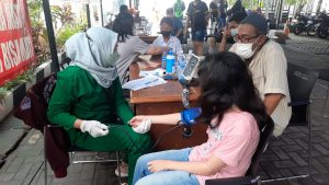 Liong Romi Mengantarkan Anaknya Untuk Dapatkan Vaksinasi Yang Diadakan Polsek Tambora
