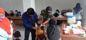 Dampingi Vaksin, Babinsa Bantu Tenangkan Anak-Anak Yang Takut Disuntik