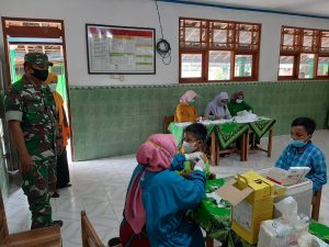 Bersama Bhabinkamtibmas, Serka Agus Heri Dampingi Anak-Anak Usia 6-11 Tahun Terima Vaksin
