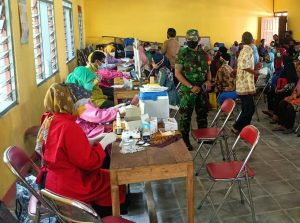 Guna Kelancaran Pelaksanaan Vaksinasi, Anggota Koramil Membantu Tenaga Kesehatan Berikan Pengamanan