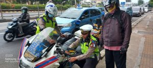 Seorang Anggota Satlantas Jakarta Barat Tertangkap Kamera Tengah Membantu Pengendara Motor Yang Kehabisan Bensin
