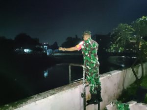 Siaga Banjir, Babinsa Koramil 01/Jatinegara Cek Arus Air Sungai Ciliwung